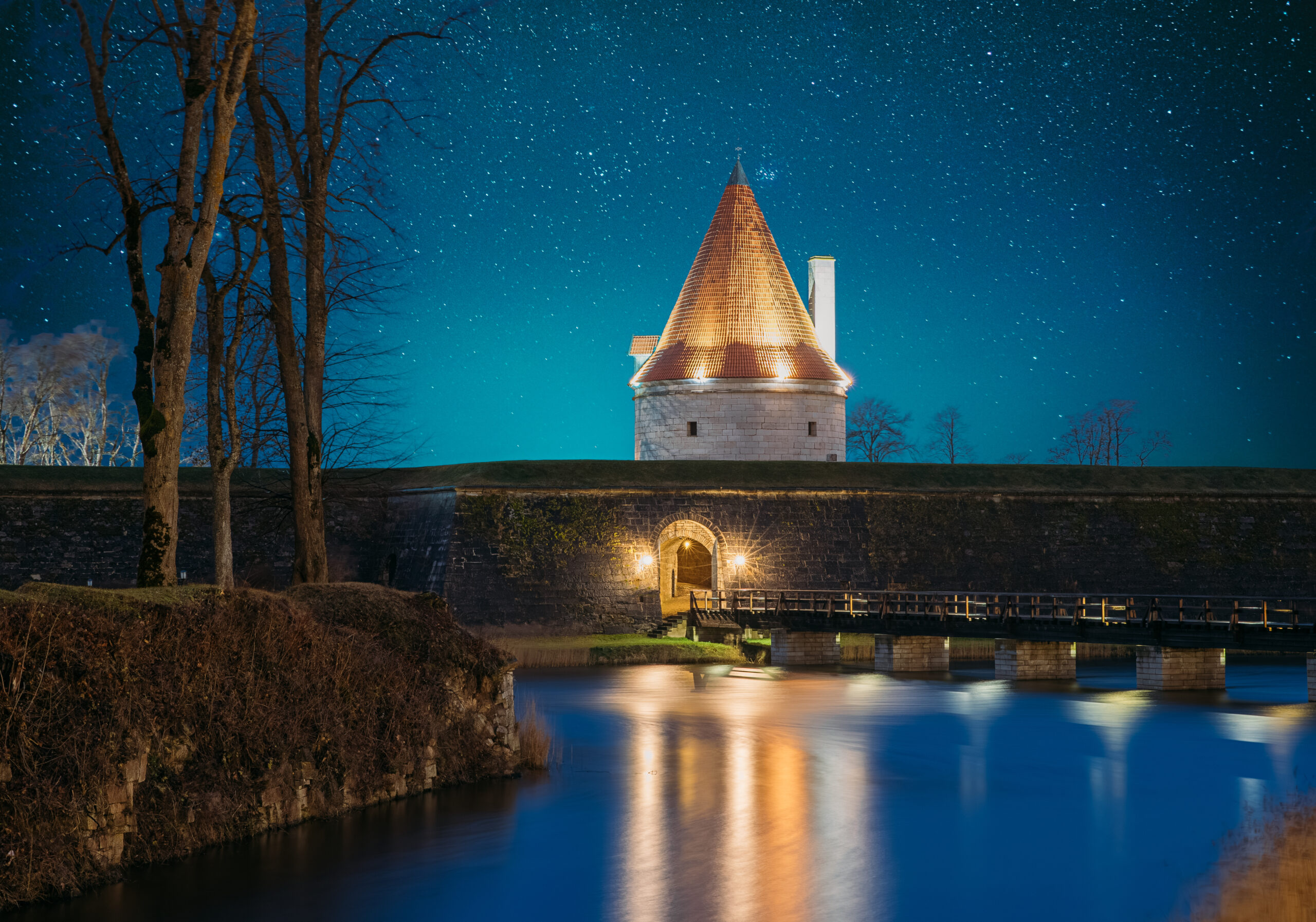 Image depicting castle with a moat at nighttime to capture the notion of a lighting designer building a mote around their design scope on a project.